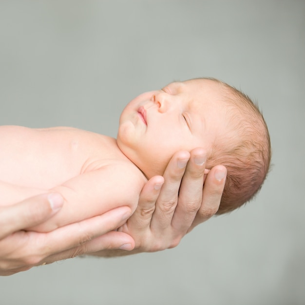 Free photo portrait of a sleeping newborn hold at hands