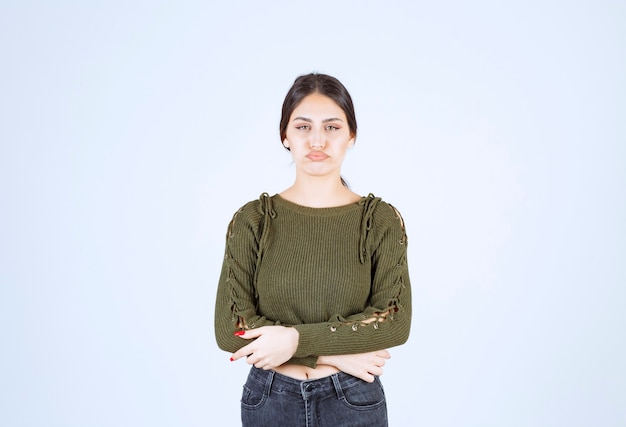 Free photo portrait of a young beautiful woman model standing and posing over white wall.