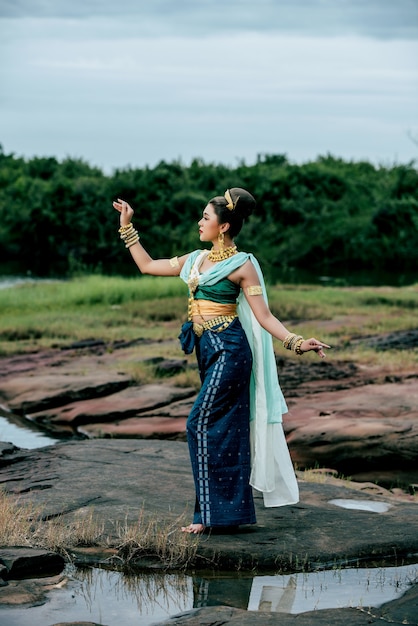 Free photo portrait young beautiful woman wearing in traditional costume with ornament posing in nature in thailand