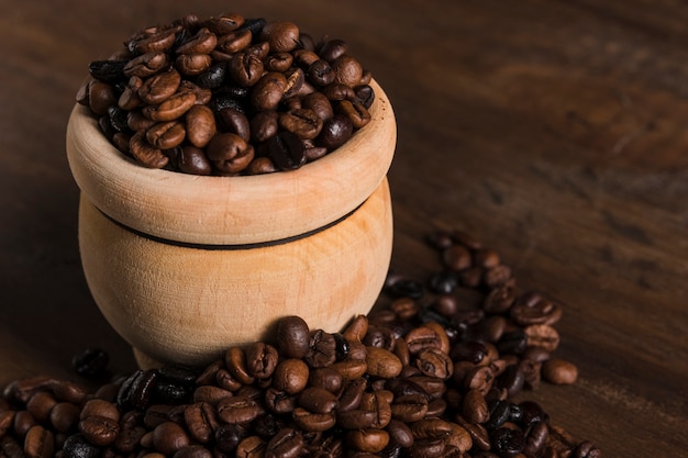 Free photo pot with coffee beans on table