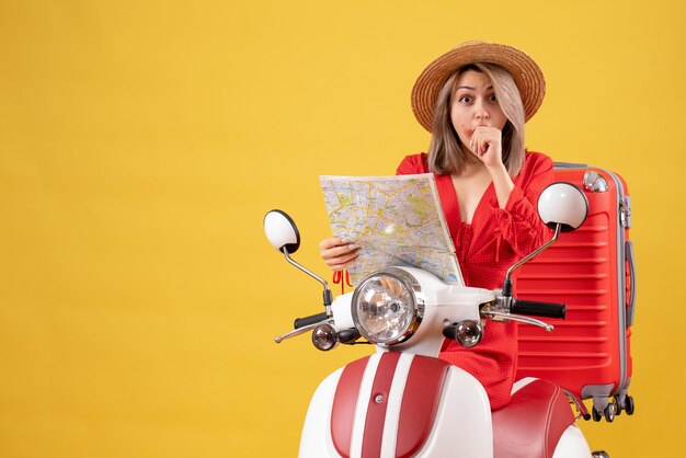 pretty girl on moped with red suitcase holding map wondering