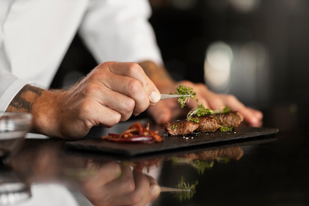 Foto gratuita chef professionista che prepara il cibo in cucina