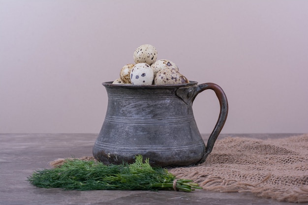 Free Photo quail eggs with herbs in a metallic cup.