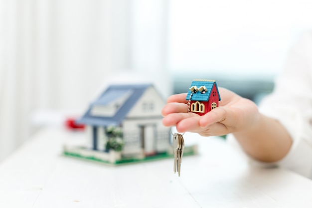 Free photo real estate agent with house model and keys