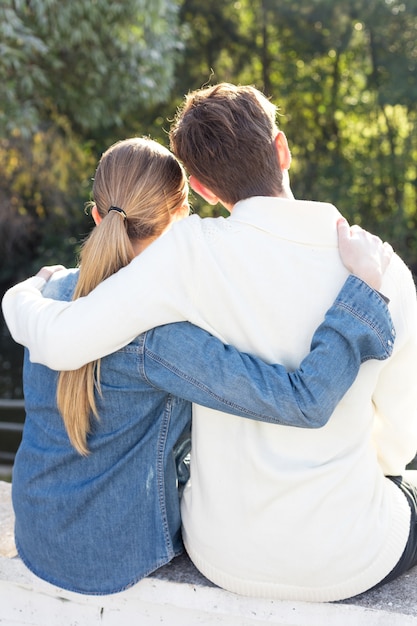 Free photo rear view of couple hugging and enjoying the scenery