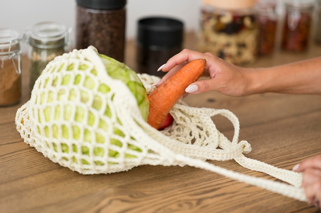 Free photo recyclable bag with vegetables on wooden table