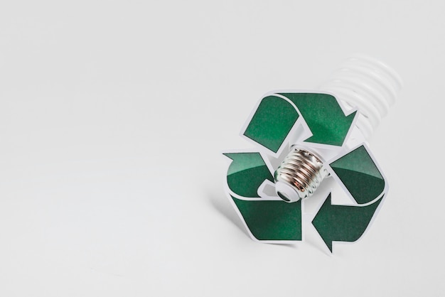 Free photo recycle icon on compact fluorescent light bulb against white background