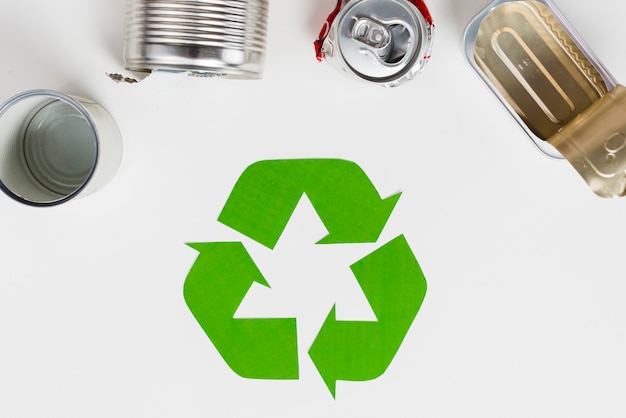 Free photo recycling symbol beside used metallic packaging