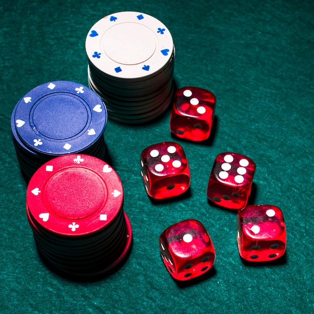 Free photo red dices and casino chip stacks on green poker table