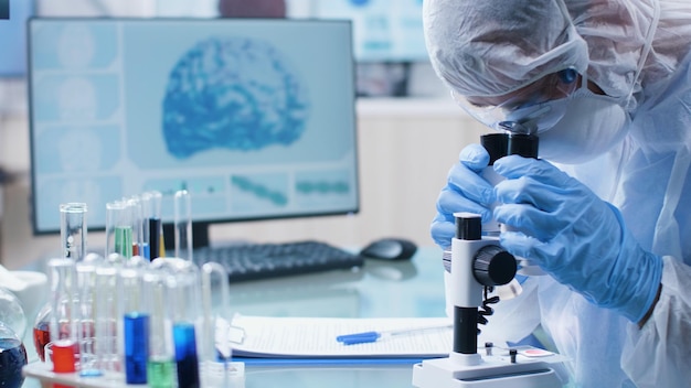 Free Photo scientist chemist researcher doctor analyzing dna sample using medical microscope developing vaccine against coronavirus during biochemistry experiment in hospital laboratory. medicine concept