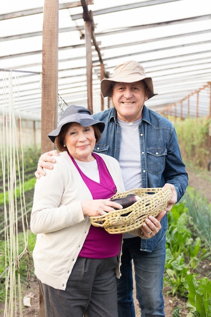 Free photo senior couple enjoying the harvest of eggplants