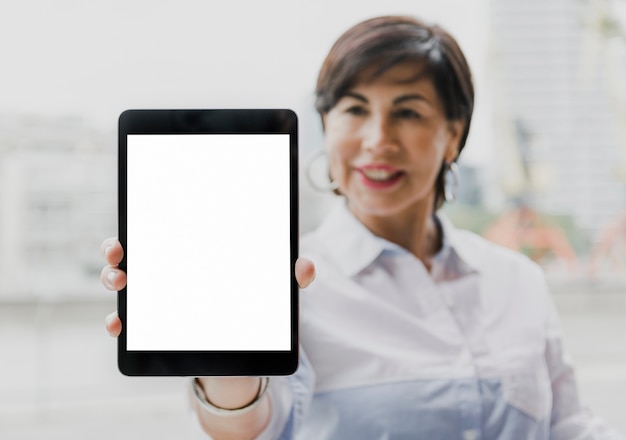 Free photo senior holding a mockup tablet