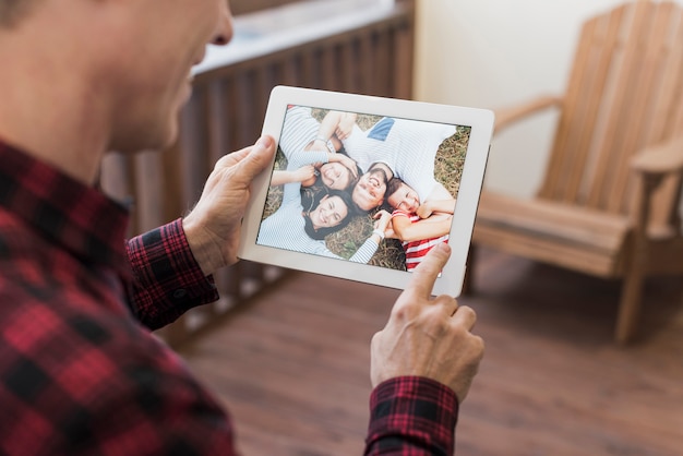 Senior man looking on photos with his children and grandchildren