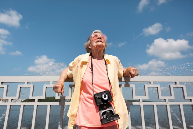 Free photo senior traveler holding a camera