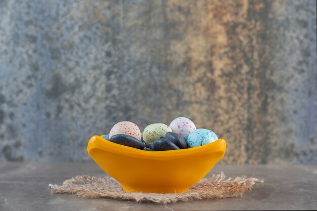 Free Photo side view of bright multicolored stone candies in orange bowl.