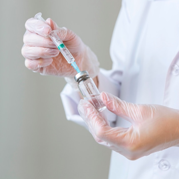 Free Photo side view of female researcher with gloves holding syringe