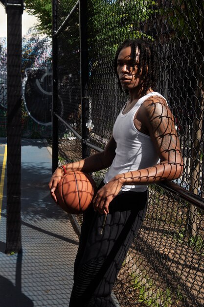 Side view man holding basket ball