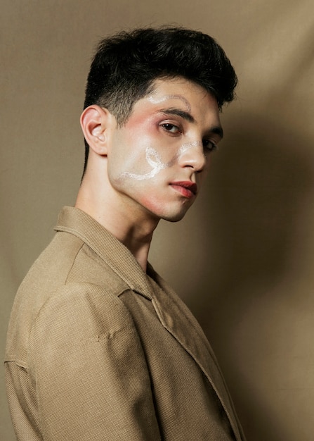 Free photo side view of man in suit with painted face