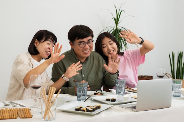 Free Photo side view smiley family eating with laptop