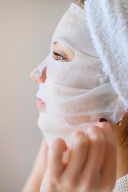 Free Photo side view of woman applying face mask