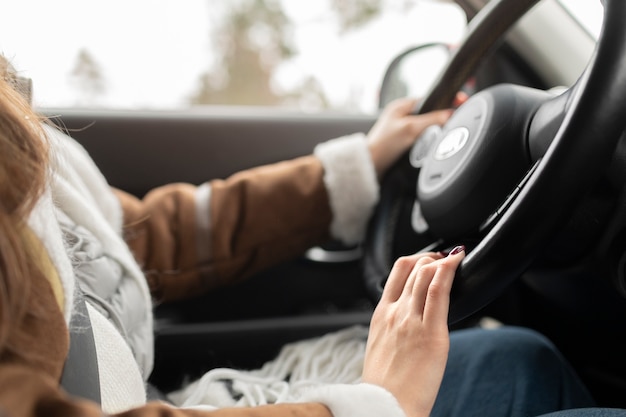 無料Photo 冬の遠征のために車を運転している女性の側面図