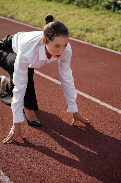 Free photo side view woman running in suit