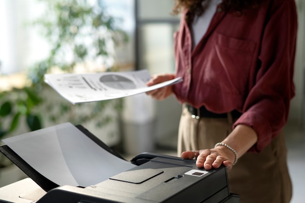 Free photo side view woman using printer