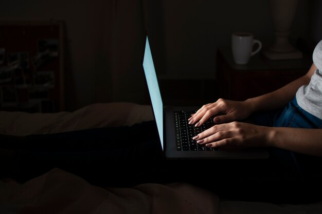 Side view of woman working late at home on laptop