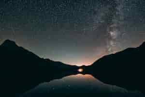 Free photo silhouette of mountain and calm body of water