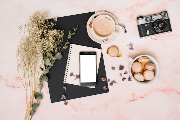 Free photo smartphone with cookies, camera and coffee cup on table