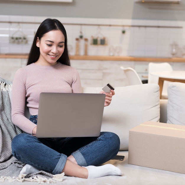 Free photo smiley woman shopping online with laptop and credit card