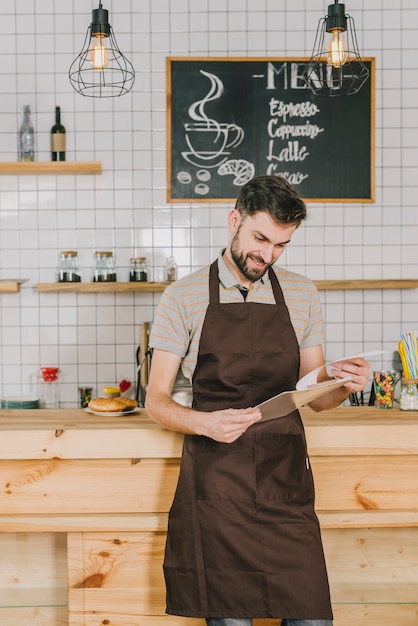 Free photo smiling bartender reading menu