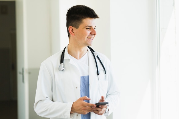 Free photo smiling doctor with smartphone
