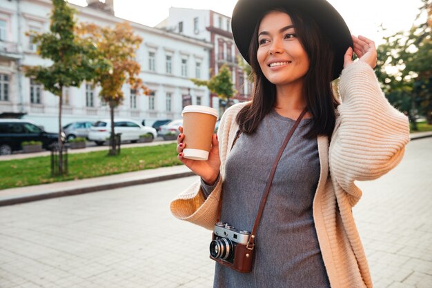 Smiling stylish woman holding coffee cup