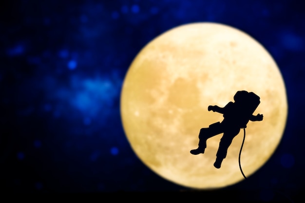 Free photo spaceman silhouette over a full moon