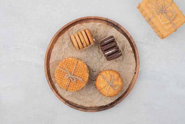 Stack of Christmas cookies tied with rope on wooden plate