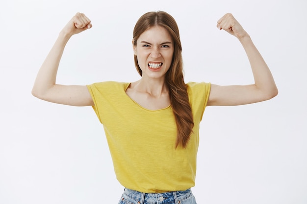 Free Photo strong and powerful girl flexing biceps, showing her strength