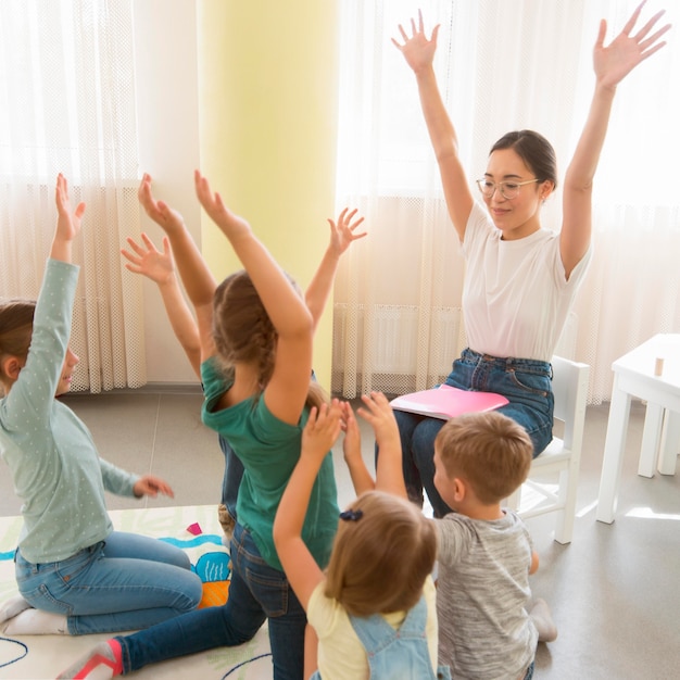 Free Photo students playing a game with their kindergarten teacher