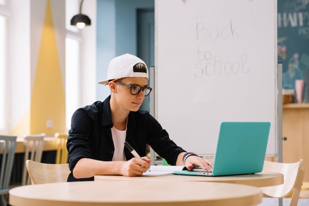 Free photo stylish student watching laptop