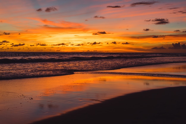 Free photo sunset on the ocean. beautiful bright sky, reflection in water, waves.