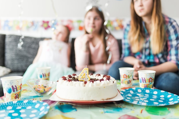 Tasty cake near guests on birthday party