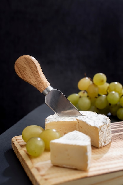 Free photo tasty grapes with brie cheese on a board