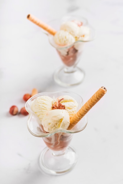 Free photo tasty ice cream scoop in glass bowl and nuts