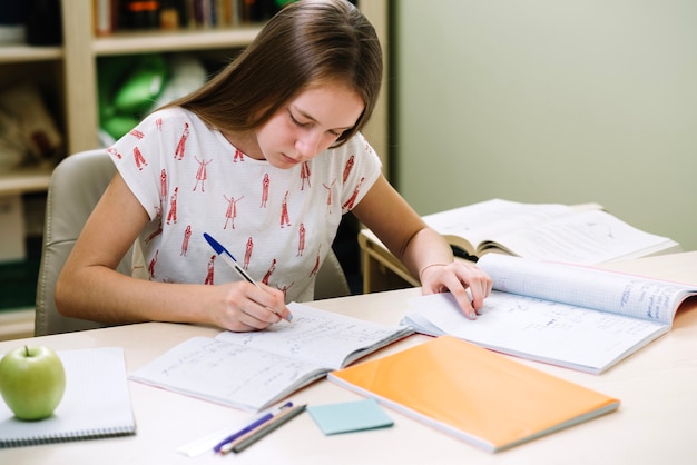 Free photo thoughtful girl student sitting and writing