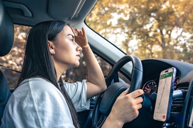 無料Photo 疲れた若い女性の運転手が頭痛と偏頭痛で車を運転している