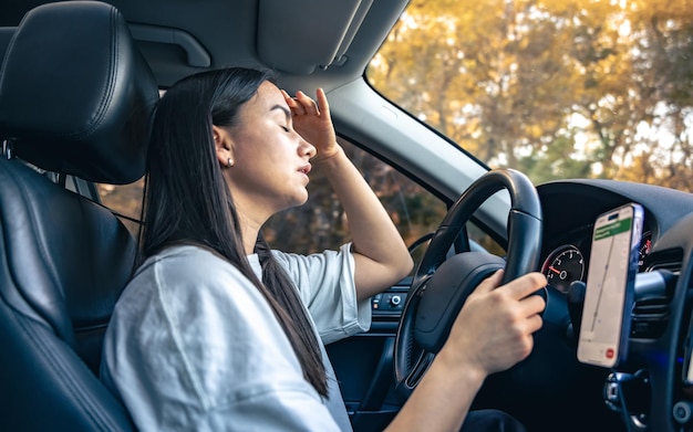 無料Photo 疲れた若い女性の運転手が頭痛と偏頭痛で車を運転している