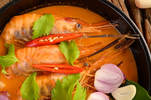 Free photo tom yum kung thai hot spicy soup shrimp with lemon grass,lemon,galangal and chilli on wooden table, thailand food