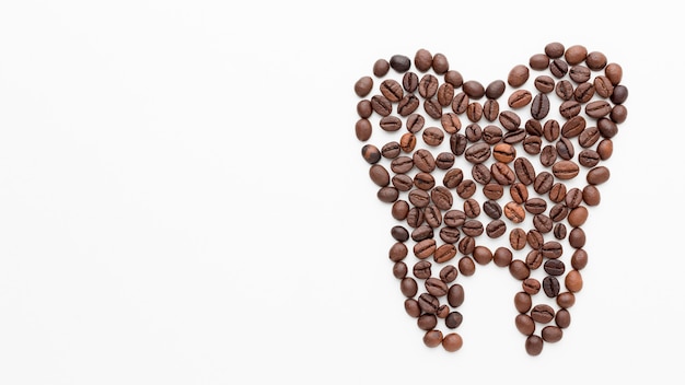 Free photo tooth shape made of coffee beans with copy-space