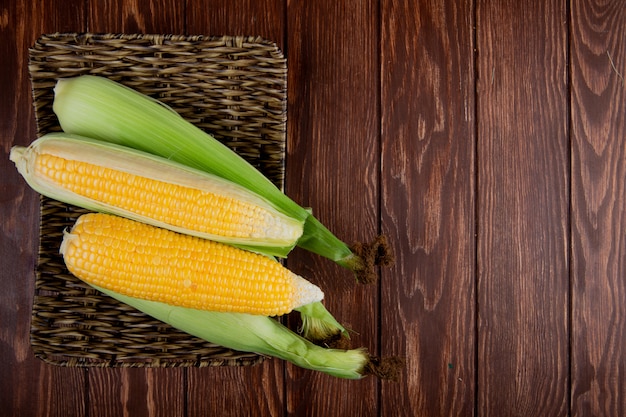 Top view of basket plate with corns on left side and wood with copy space