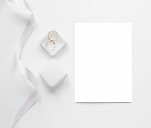 Free Photo top view blank paper sheet beside engagement rings